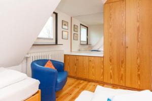 ヴェニングシュテットにあるWohnung-re-Sylter-Bojeの青い椅子とベッドが備わる客室です。