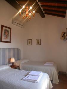 a bedroom with two beds and a chandelier at Ciliegio in Cortona