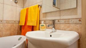 łazienka z umywalką, toaletą i ręcznikami w obiekcie Apartments Toni w Omišu