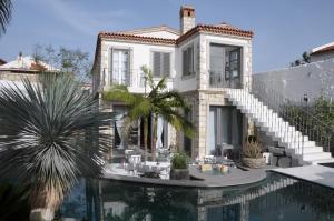 a house with a swimming pool in front of a house at Alaçatı Ala Hotel - Special Category in Alacati