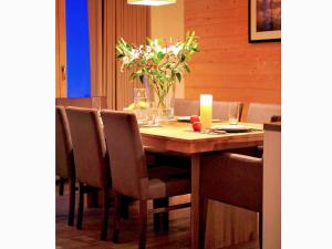 uma mesa de jantar com cadeiras e um vaso de flores em Lavish Holiday Home in H r mence with Balcony em Hérémence