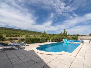 Pouzols-MinervoisにあるLuxury villa with private poolのスイミングプール(椅子2脚、パティオ付)