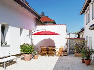 a patio with a table and chairs and an umbrella at Ruhige Ferienwohnung mit Parkplatz in Thale in Thale