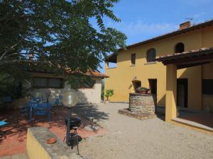 un patio trasero de una casa con una parrilla delante en Belvilla by OYO Podere Pulicciano Pozzo, en Pian di Scò