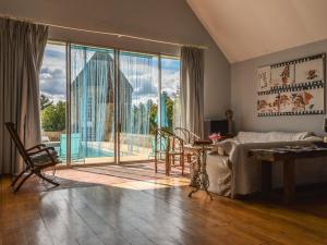 ein Wohnzimmer mit einem Bett und einem großen Fenster in der Unterkunft Gorgeous manor in the Auvergne with private pool in Meaulne