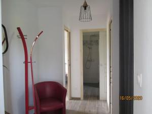 a red chair in a room with a bathroom at Comfy holiday home in Crux La Ville with fenced garden in Crux-la-Ville