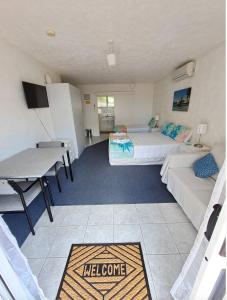 a room with two beds and a desk and a table at Paihia Star Motel in Paihia