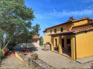 una gran casa amarilla con un patio delante en Belvilla by OYO Podere Pulicciano Pozzo, en Pian di Scò