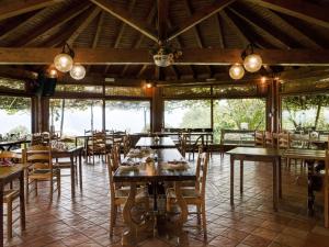 a dining room with tables and chairs and windows at Farmhouse in Verbania with Lake Views in Verbania
