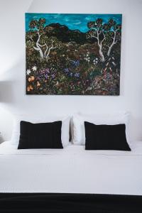a painting hangs above a bed with two pillows at Johnstone Terrace in Castlemaine