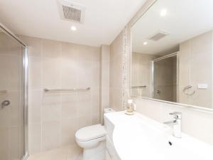 ein Badezimmer mit einem WC, einem Waschbecken und einem Spiegel in der Unterkunft Wallis Court 6 in Forster