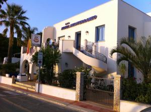 un edificio bianco sul lato di una strada di Hotel Ristorante Mediterraneo Faro a San Vito lo Capo