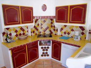 a small kitchen with red cabinets and a stove at Gorgeous Villa in Bagnols en For t in Bagnols-en-Forêt