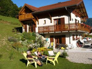 two people sitting in chairs in front of a house at Chalet Gîte Le Titlis in Bernex