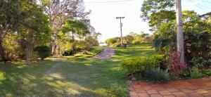 une cour herbeuse avec des arbres et un sentier dans l'établissement Camping São Pedro - Área de acampamento dentro de Diamantina, à Diamantina