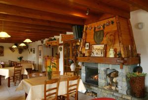 sala de estar con chimenea, mesa y sillas en Chalet Gîte Le Titlis, en Bernex