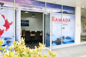 Ramada Suites by Wyndham Albany في أوكلاند: مبنى مكتب مع قاعة اجتماعات في الخلفية