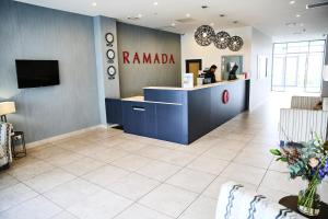 a lobby of a pharmacy with a counter and a person at Ramada Suites by Wyndham Albany in Auckland