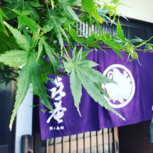 um sinal num edifício com plantas verdes em KIAN the guest house em Matsue