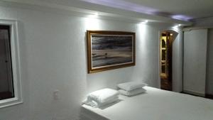 a bedroom with a bed with a picture on the wall at Perohouse in Cabo Frio +45 photos