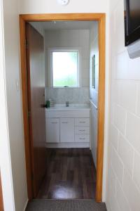 een badkamer met een wastafel en een raam bij Flaxbourne Motels in Ward