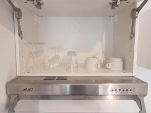 una cocina con una estantería con artículos de cristal. en F2 duplex standing de 35 m2 à 3 min du canal de l'ourcq en Tremblay En France