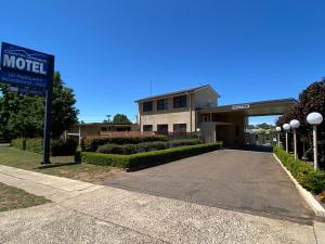 una señal de motel frente a un edificio en Country Gardens Motel, en Coonabarabran