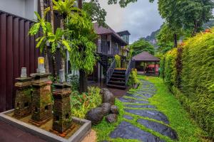 einen Garten mit einem Steinweg neben einem Haus in der Unterkunft The Cliff Elegance Resort in Ao Nang Beach