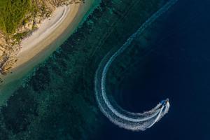 an aerial view of a boat in the water next to a beach at Six Senses Con Dao - Turtle Island Paradise in Con Dao