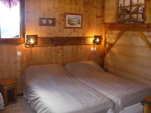 a bedroom with a bed in a wooden wall at Chalet Gîte Le Titlis in Bernex