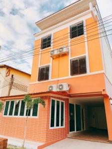 an orange and white building with at Lomluang hostel&hotel in Nan