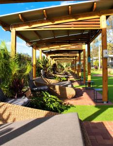 a patio area with chairs, tables, and umbrellas at BIG4 Gold Coast Holiday Park in Gold Coast