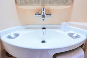 a white sink in a bathroom next to a bath tub at Premiere Classe Villepinte Centre - Parc des Expositions in Villepinte