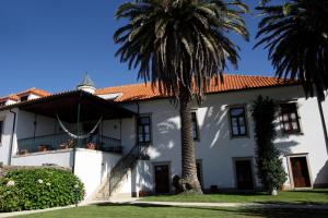 a white house with palm trees in front of it at Solar de Chacim - Turismo de Habitação in Chacim