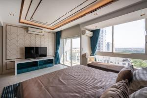 ナ・ジョムティエンにあるVeranda Pattaya/3BR Seaview/ExecutiveSuiteの大きなベッドとテレビのある寝室