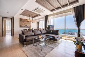 a living room with a leather couch and a glass table at Veranda Residence 3BR - Ocean Views - Luxury Stay in Na Jomtien