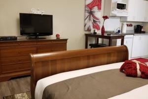 Schlafzimmer mit einem Bett und einem Flachbild-TV in der Unterkunft Cozy Studio #14, By Amazing Property Rentals in Gatineau