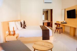 a hotel room with a bed and a table and chairs at New Sunari Lovina Beach Resort in Lovina