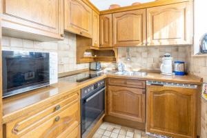 uma cozinha com armários de madeira e um forno com placa de fogão em Bergsonne em Bad Hindelang