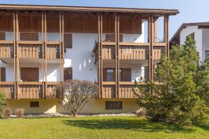 um edifício de apartamentos com varandas em madeira e um quintal em Bergsonne em Bad Hindelang