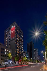 a tall building with a red sign on the side of it at Ramada by Wyndham Seoul Dongdaemun in Seoul