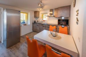 a kitchen with a table and orange chairs at Chalet Ramona in Grächen