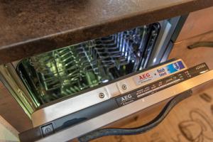 a dishwasher with its door open with a machine at Chalet Ramona in Grächen