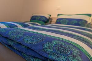 two beds with blue and green sheets and pillows at Chalet Ramona in Grächen