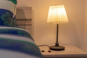a lamp sitting on a table next to a bed at Chalet Ramona in Grächen
