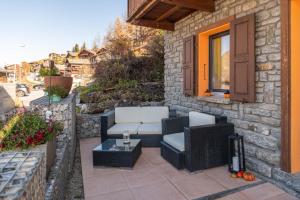 a patio with two chairs and a table and a window at Chalet Ramona in Grächen