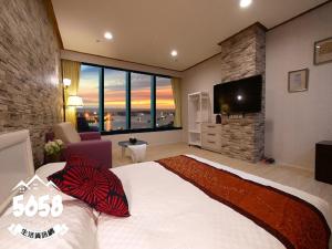 um quarto com uma cama grande e uma televisão de ecrã plano em 85 Season em Kaohsiung