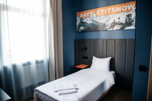 エストサドクにあるAYS Let It Snow Hotel Rosa Khutorのベッドルーム1室(壁にポスター付きのベッド1台付)