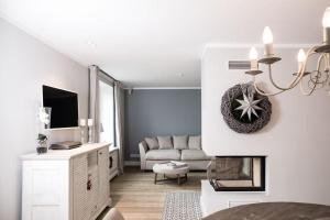 ein weißes Wohnzimmer mit einem Sofa und einem Tisch in der Unterkunft Strön Hüs    in Hörnum