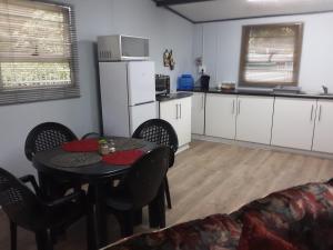 a living room with a table and a kitchen at Nadine's Self-Catering Accommodation in Stormsrivier